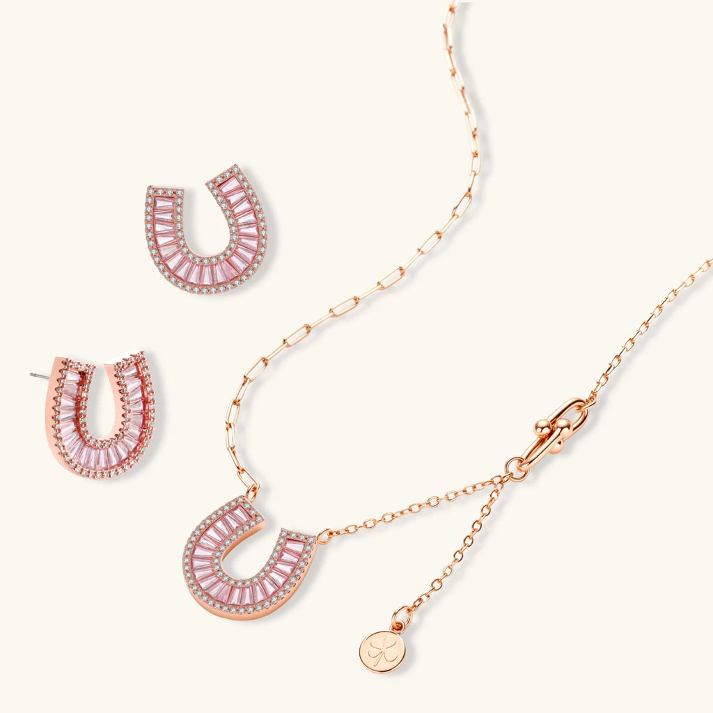 Sparkling horseshoe-shaped jewelry set with AAA cubic zirconia in gold-plated and white gold finishes on cream background.