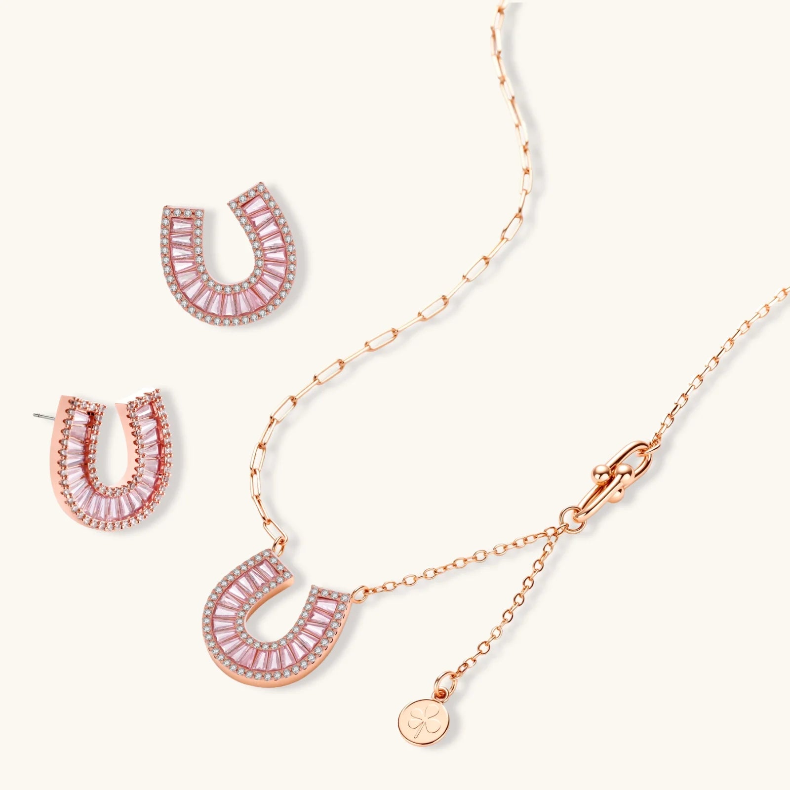 Sparkling horseshoe-shaped jewelry set with AAA cubic zirconia in gold-plated and white gold finishes on cream background.