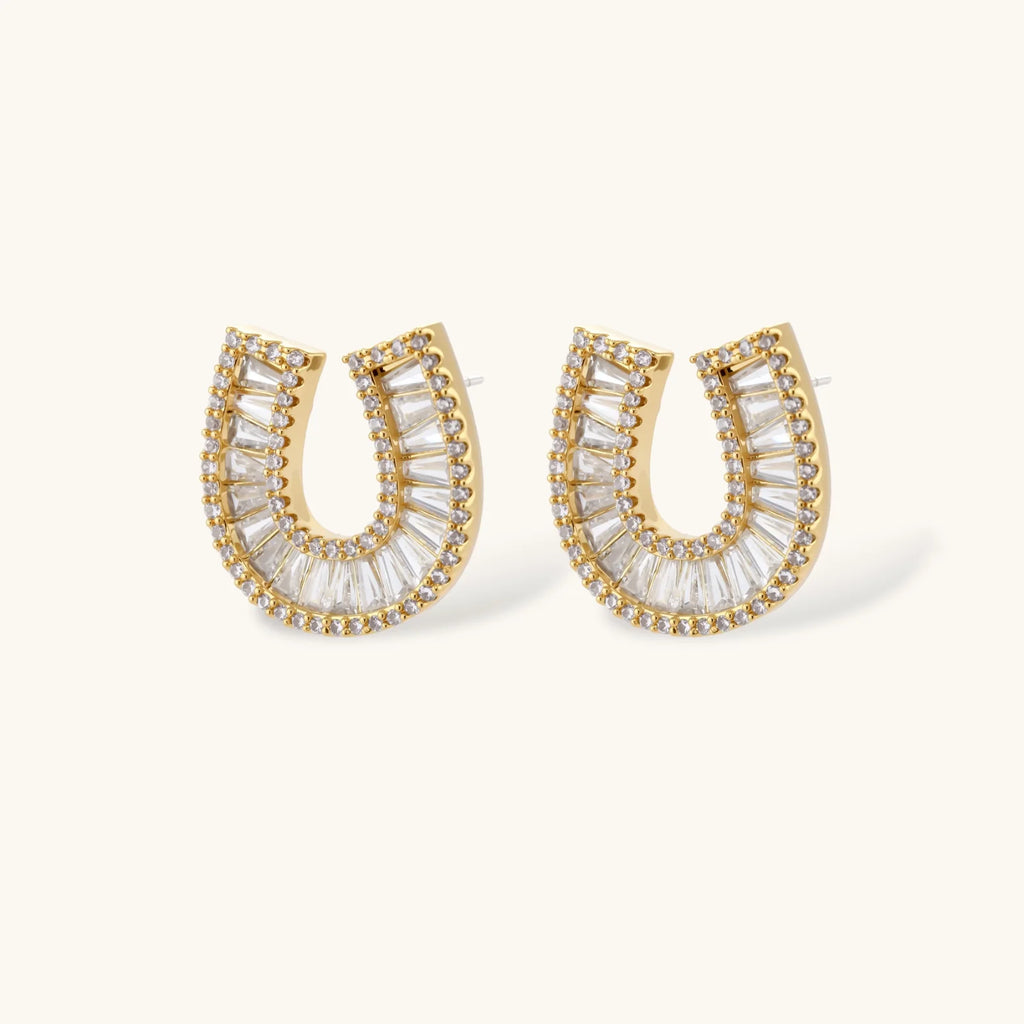 Sparkling horseshoe-shaped jewelry set with AAA cubic zirconia in gold-plated and white gold finishes on cream background.