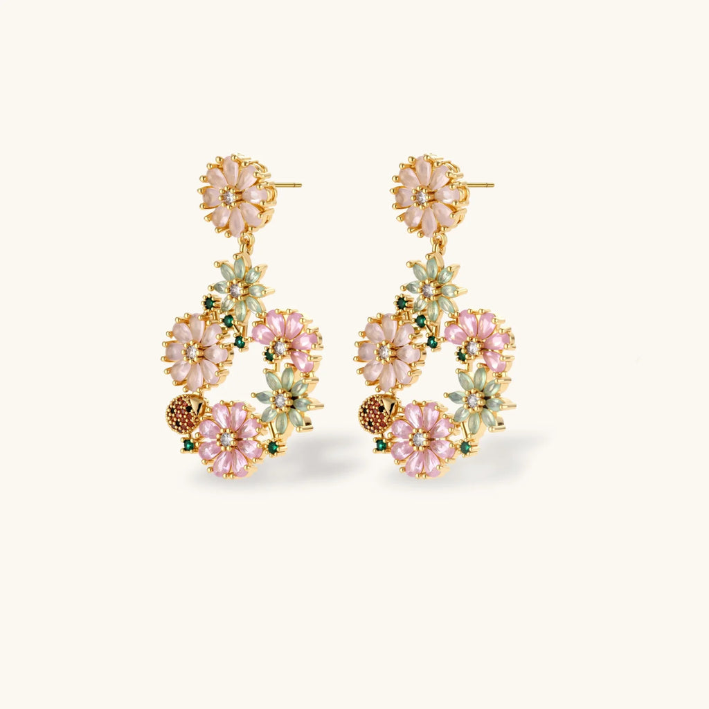 14K gold plated jewelry set with pink and green cubic zirconia flowers arranged in wreath design on cream background
