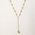 Adjustable gold lariat necklace with freshwater pearls nested in delicate cage settings and Y-shaped tassel drop