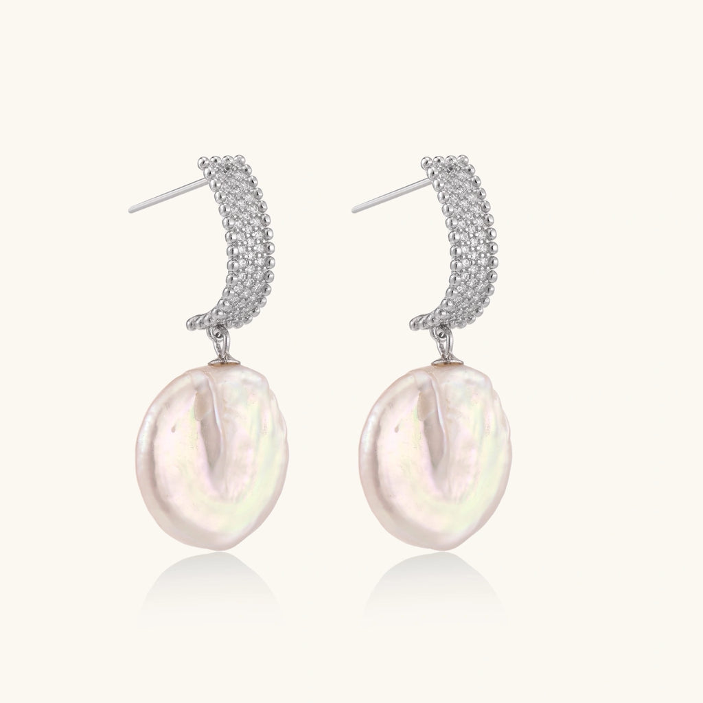 Rhodium-plated silver curved stud with pave stones and baroque pearl drop on white background