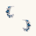 White gold plated hoop earrings with woven blue denim fabric through organic branch-like metal framework