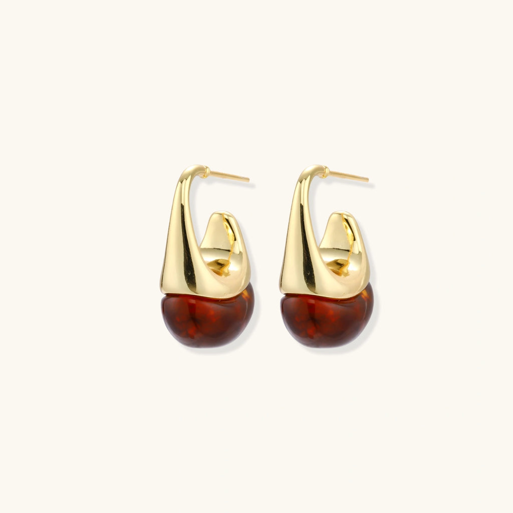 Modern drop earrings with curved gold-plated copper tops and amber resin bottoms creating an organic teardrop silhouette.